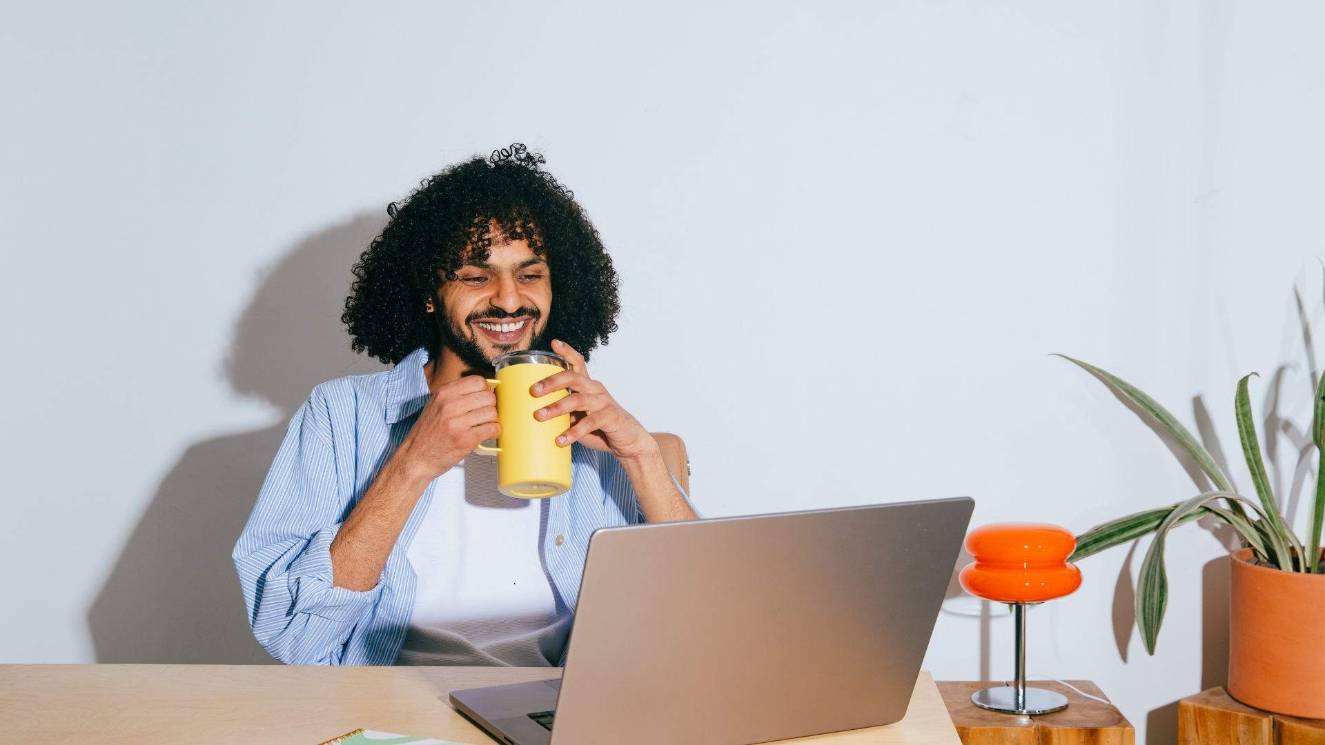 man enjoying coffee in front of laptop