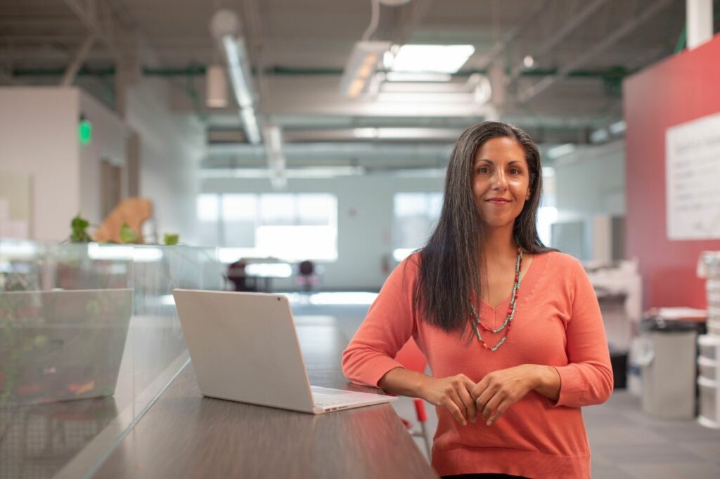 Woman in peach shirt with long dark hair