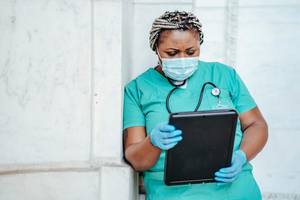 Nurse in scrubs using a tablet
