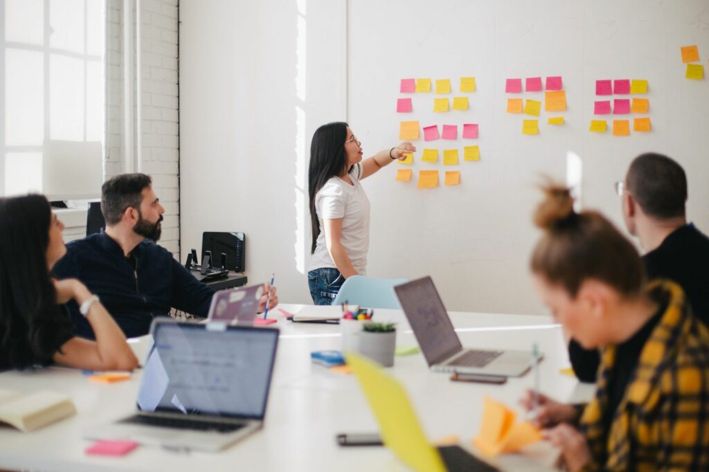 Project manager explaining sticky notes on wall