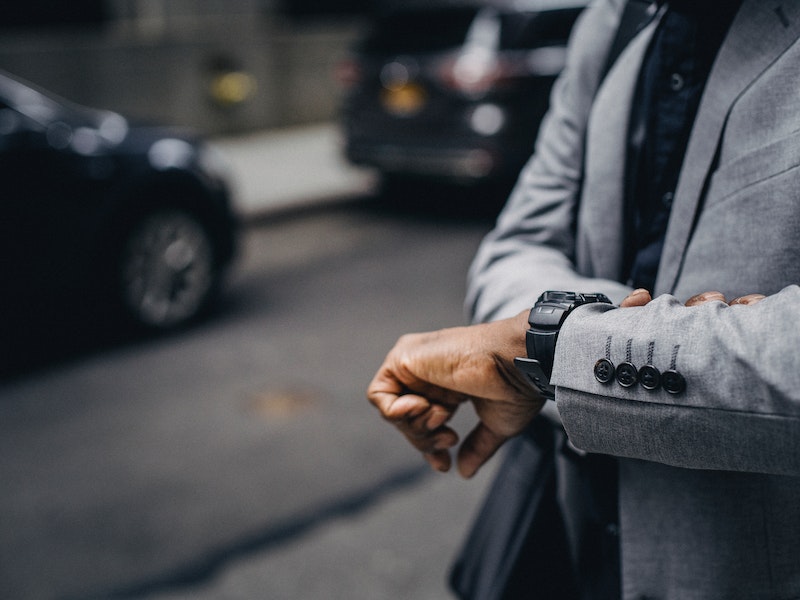 Well dressed man looking at wrist watch